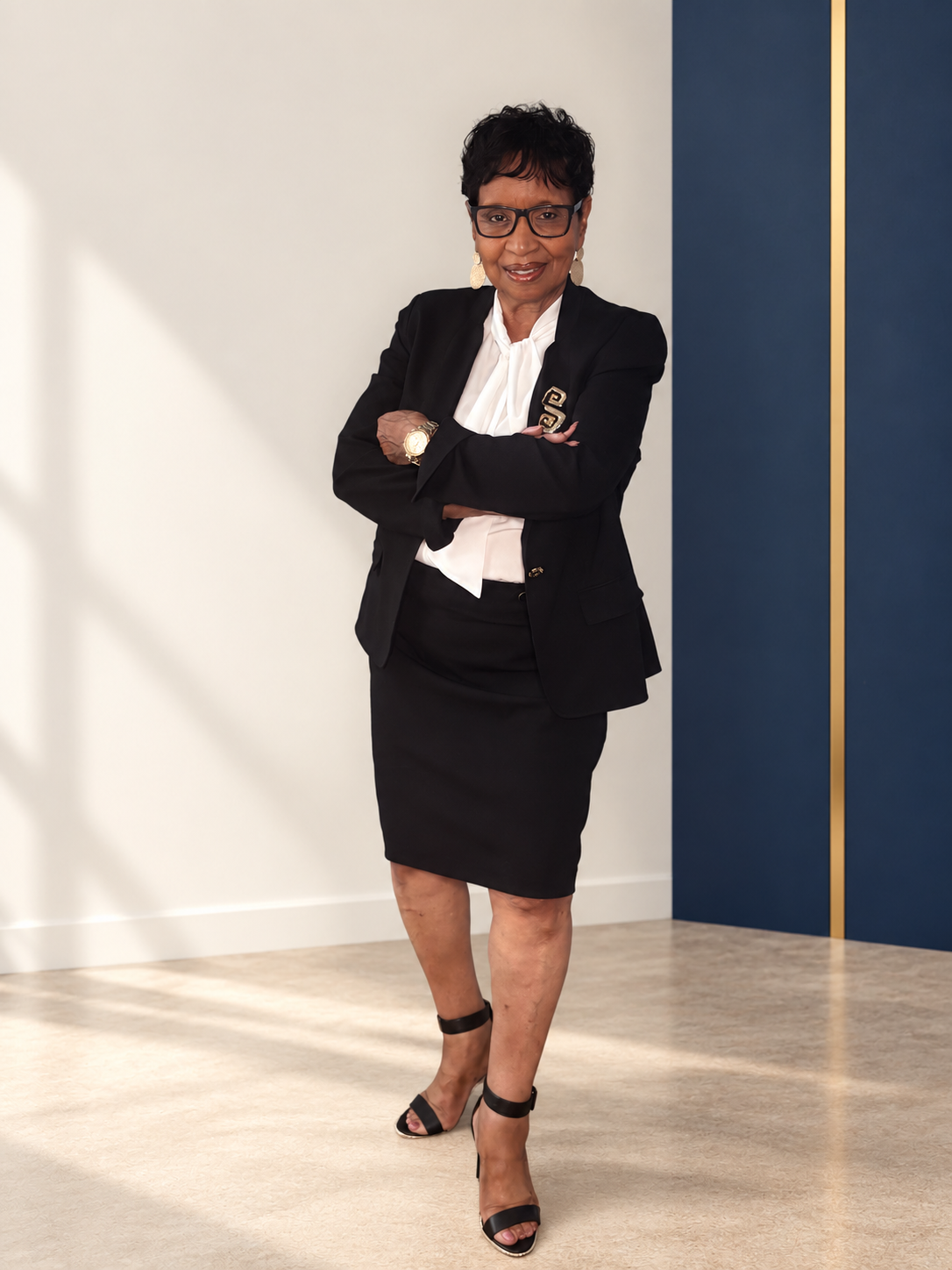 Carole Peaks Cheatam standing with her arms folded in a black suit